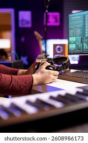 Composer getting ready for recording session in his home studio, using audio headset and daw software on pc to create new songs. Songwriter artist mixing tunes for music industry. Close up.