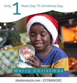 Composite of african american boy in santa hat holding snow globe and merry christmas text. Only 1 more day till christmas day, childhood, gift, happy, christmas festivity, winter holiday, celebrate. - Powered by Shutterstock