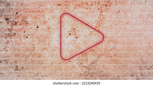 Composite of digital illuminated red play button icon against grunge brick wall, copy space. Music, movie, multimedia, playing, pushing, symbol, control and technology concept. - Powered by Shutterstock