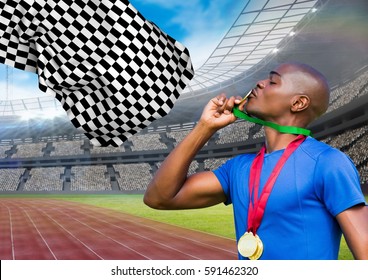 Composite image of athlete kissing his gold medal in stadium