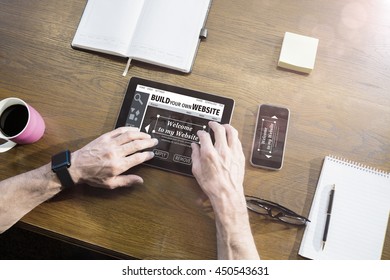 Composite image of build website interface against businessman using tablet