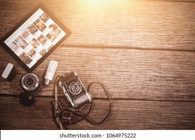 Composite image of close up of old fashioned camera with digital tablet on table