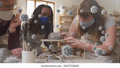 Composite image of covid-19 cells against group of diverse female potters working on pottery wheel. pottery and covid-19 pandemic concept - Powered by Shutterstock