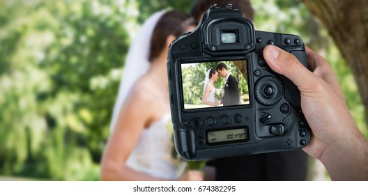 Composite image of cropped hand of photographer holding camera  - Powered by Shutterstock