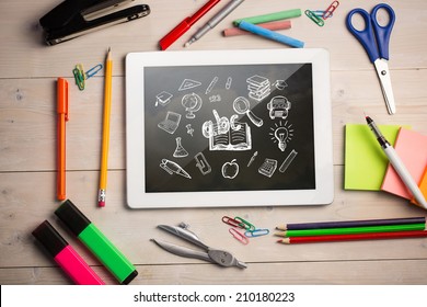 Composite image of digital tablet on students desk showing education doodles