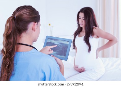 Composite Image Of Doctor Looking At Xray On Tablet