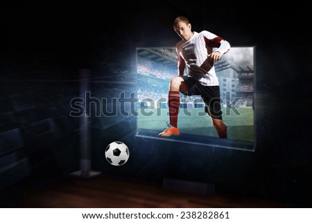 Composite image of football player ball through tv against vast football stadium with fans