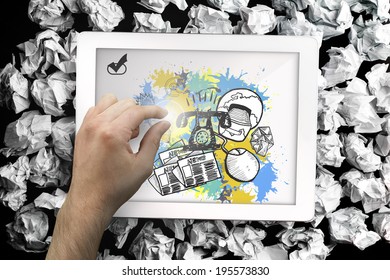 Composite image of hand touching tablet showing business graphics on paint splashes