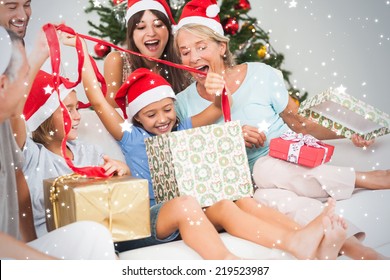 Composite Image Of Happy Family At Christmas Opening Gifts Together Against Snow