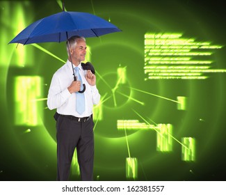 Composite image of happy mature businessman holding umbrella - Powered by Shutterstock