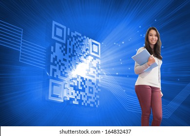 Composite image of student standing in a computer room and holding a folder while smiling