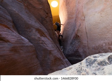 Composite Image Of Young Woman Climbing Through Slot Canyon To Sunset, Utah, USA