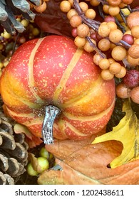 A composite of natural and decorative objects and elements including pumpkins, berries, leaves, flowers, and vines for the autumn season in a vertical format. 