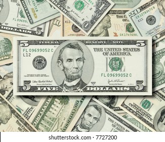 Composite Shot Of Different American Dollar Bills Piled Together With Lincoln's 5 Dollar Bill In Front.