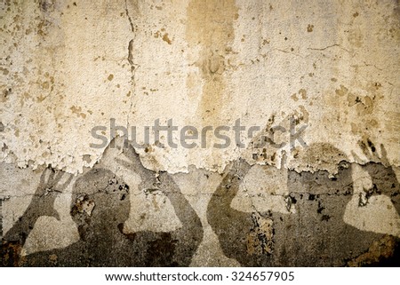 A composite of two terrified shadows on a wall in Iran or any war torn country in the Middle East.