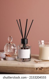 Composition With Aromatic Reed Air Freshener On Wooden Table Near Pink Wall