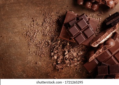 Composición de barras y trozos de leche y chocolate negro diferentes, cacao rallado sobre fondo marrón arriba abajo