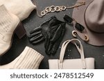 Composition with black leather gloves and stylish female accessories on dark background