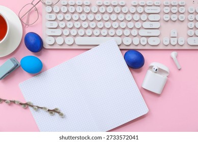 Composition with blank notebook, gadgets and Easter eggs on pink background