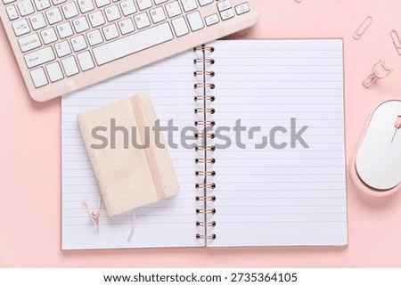 Composition with blank open notebook, computer keyboard and mouse on pink background, closeup