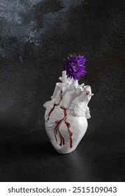 Composition with bleeding and broken heart and flower - a concept of emotional pain in relationship or breakup.