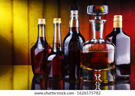 Composition with bottles of assorted alcoholic beverages.