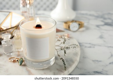 Composition with burning soy candle on white marble table, space for text - Powered by Shutterstock