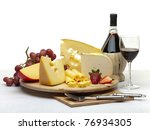 Composition of cheese, grapes, bottles and glasses of wine and strawberries on a wooden round tray on a white tablecloth, isolated on a white background