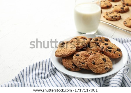 Composition with chip cookies and milk on white table