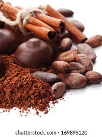 Zusammensetzung von Schokoladensüßen, Kakao und Gewürzen einzeln auf Weiß