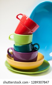 Composition With Colorful Kitchen Stuff: Mugs, Bowls, Plates. Variety Of Forms And Bright Colours. White Background