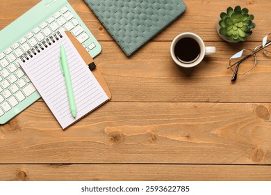 Composition with computer keyboard, cup of coffee and notebook on wooden background