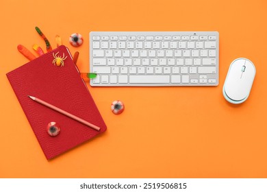 Composition with computer keyboard, mouse, notebook and candies for Halloween on color background