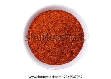 Composition consisting of variations of spices in white bowls and metal spoons on a dark concrete background