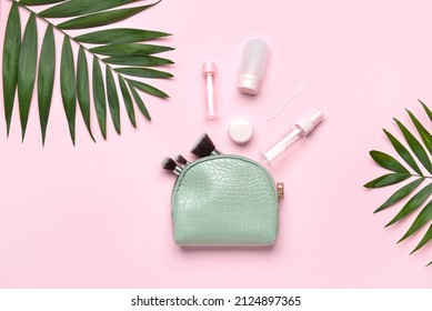 Composition With Cosmetic Bag, Travel Bottles, Makeup Brushes And Palm Leaves On Pink Background