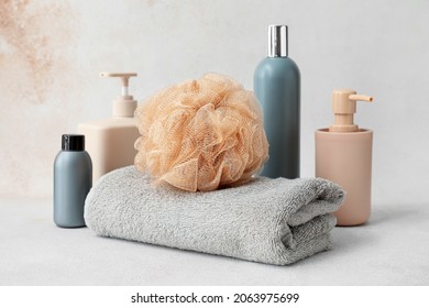 Composition with cosmetic products, towel and soft bath sponge on light background