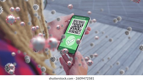 Composition of covid-19 cells floating over woman holding a smartphone with qr code on screen. covid-19 vaccination certificate and health pass concept