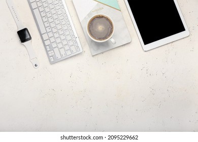 Composition with cup of coffee, smartwatch, notebook and tablet computer on light background