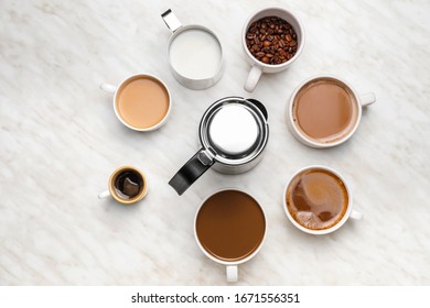 Composition with cups of different coffee on light background