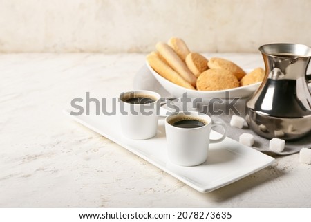 Composition with cups of tasty coffee and cookies on light background