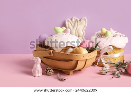 Composition with delicious decorated Easter cake and painted eggs in wooden basket on color background