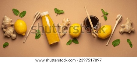 Composition with detox drink, lemons, mint, ginger, honey in glass jar and honey wooden dippers top view. Food for immunity stimulation and against flu. Healthy natural remedies to boost immune system