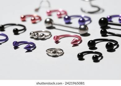 Composition with different jewelry for piercing on light background, closeup