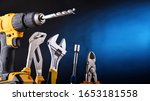 Composition with different kinds of hardware tools including cordless drill, monkey spanner and screwdriver