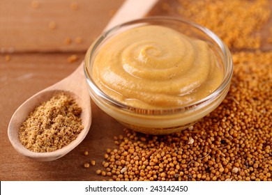 Composition of different kinds of mustard on wooden background