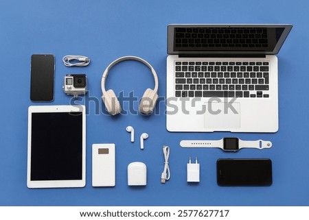 Composition with different modern gadgets on blue background