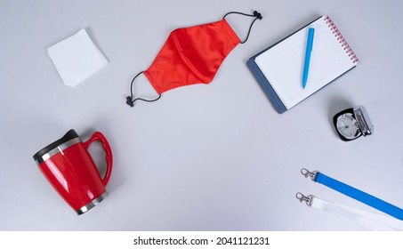 
Composition Of Different Promo Products With Rich Colors -Thermo Mugs, Lanyards Neck Strap, Pen, Silver Table Office Clock, Notebook, Paper Note, Mask Fabric Covid-19. On Grey Desk