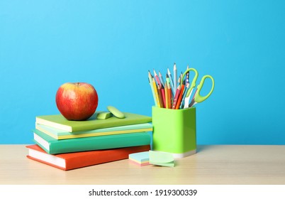 Composition with different school stationery on wooden table against light blue background. Back to school - Powered by Shutterstock