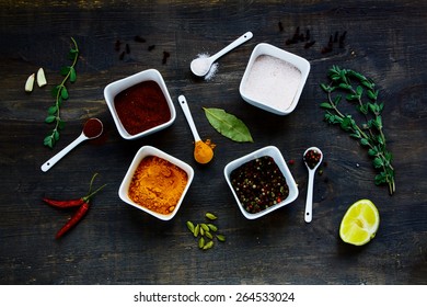Composition with different spices and herbs over rustic wooden texture. Food and cuisine ingredients. Top view.