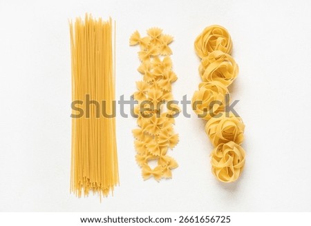 Composition with different types of raw pasta on white background